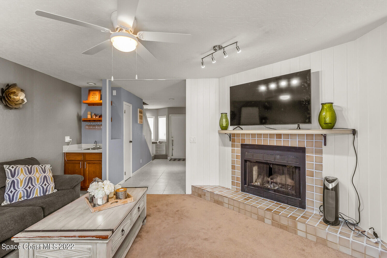 1784 Quail Trail Melbourne, FL 32935 - Photo 19 of 40 a living room with furniture a fireplace and a flat screen tv