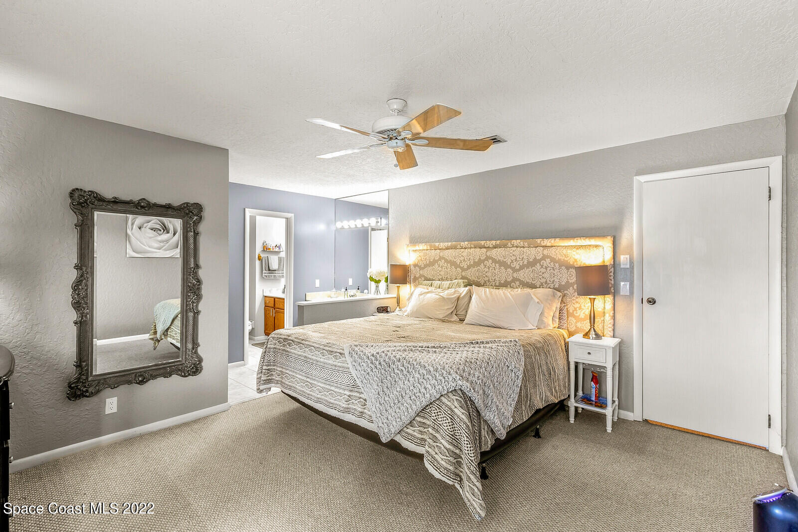 1784 Quail Trail Melbourne, FL 32935 - Photo 24 of 40 a bedroom with a bed and a mirror