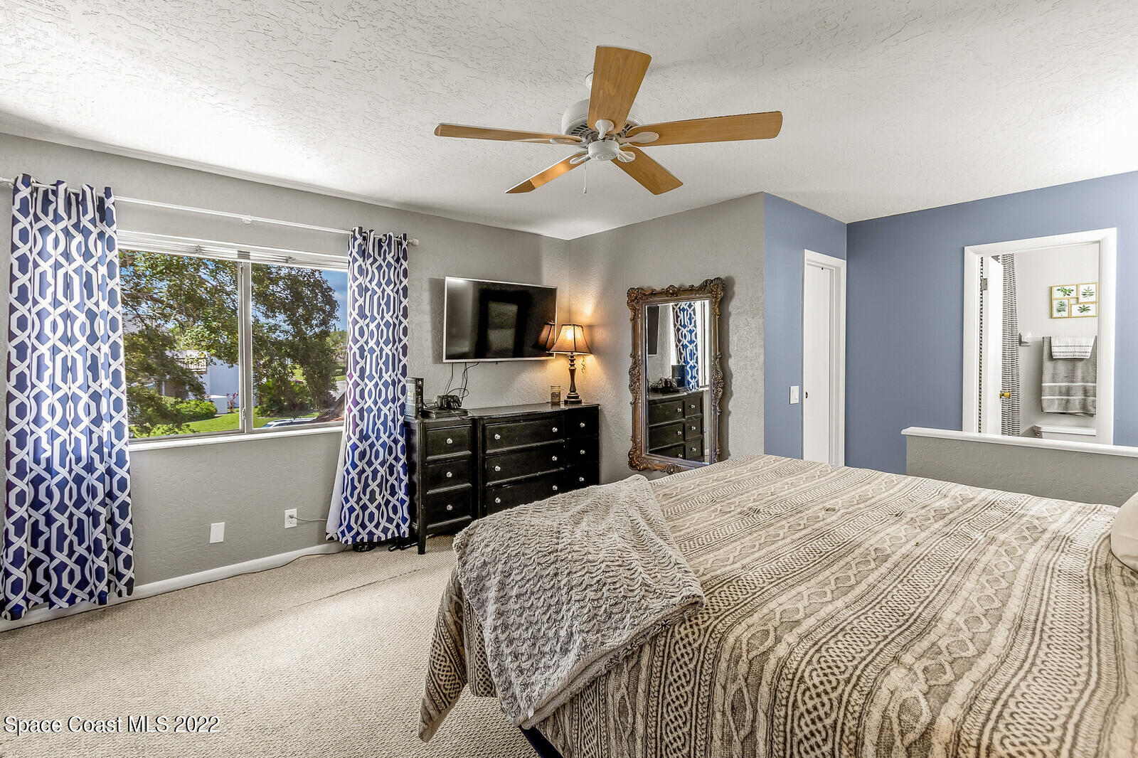 1784 Quail Trail Melbourne, FL 32935 - Photo 25 of 40 a bedroom with a bed and a flat screen tv