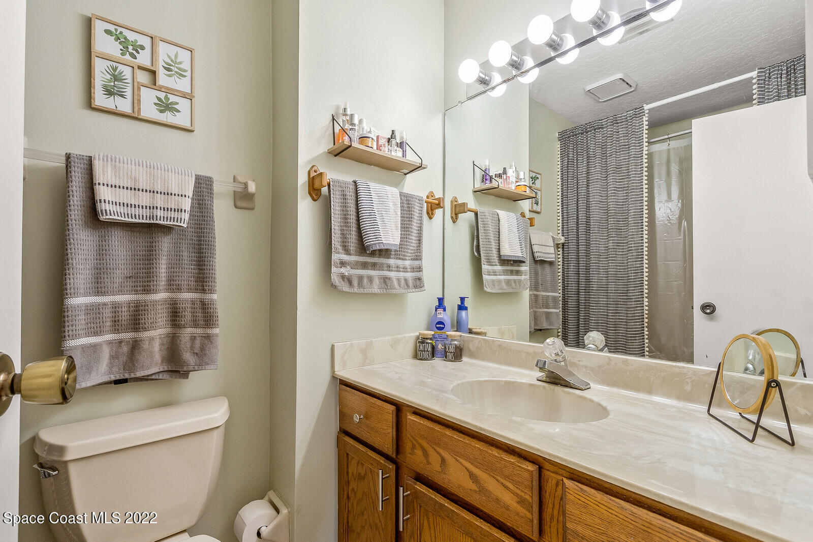 1784 Quail Trail Melbourne, FL 32935 - Photo 28 of 40 a bathroom with a sink a toilet and mirror