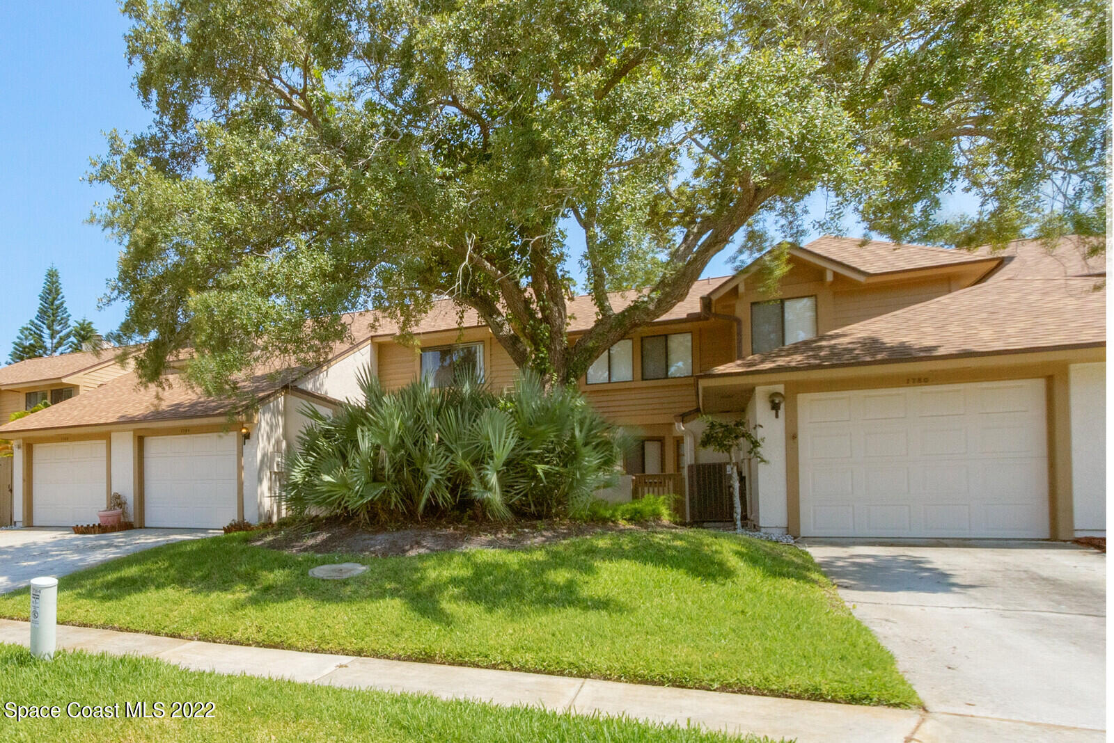 1784 Quail Trail Melbourne, FL 32935 - Photo 3 of 40 a front view of a house with a garden and yard