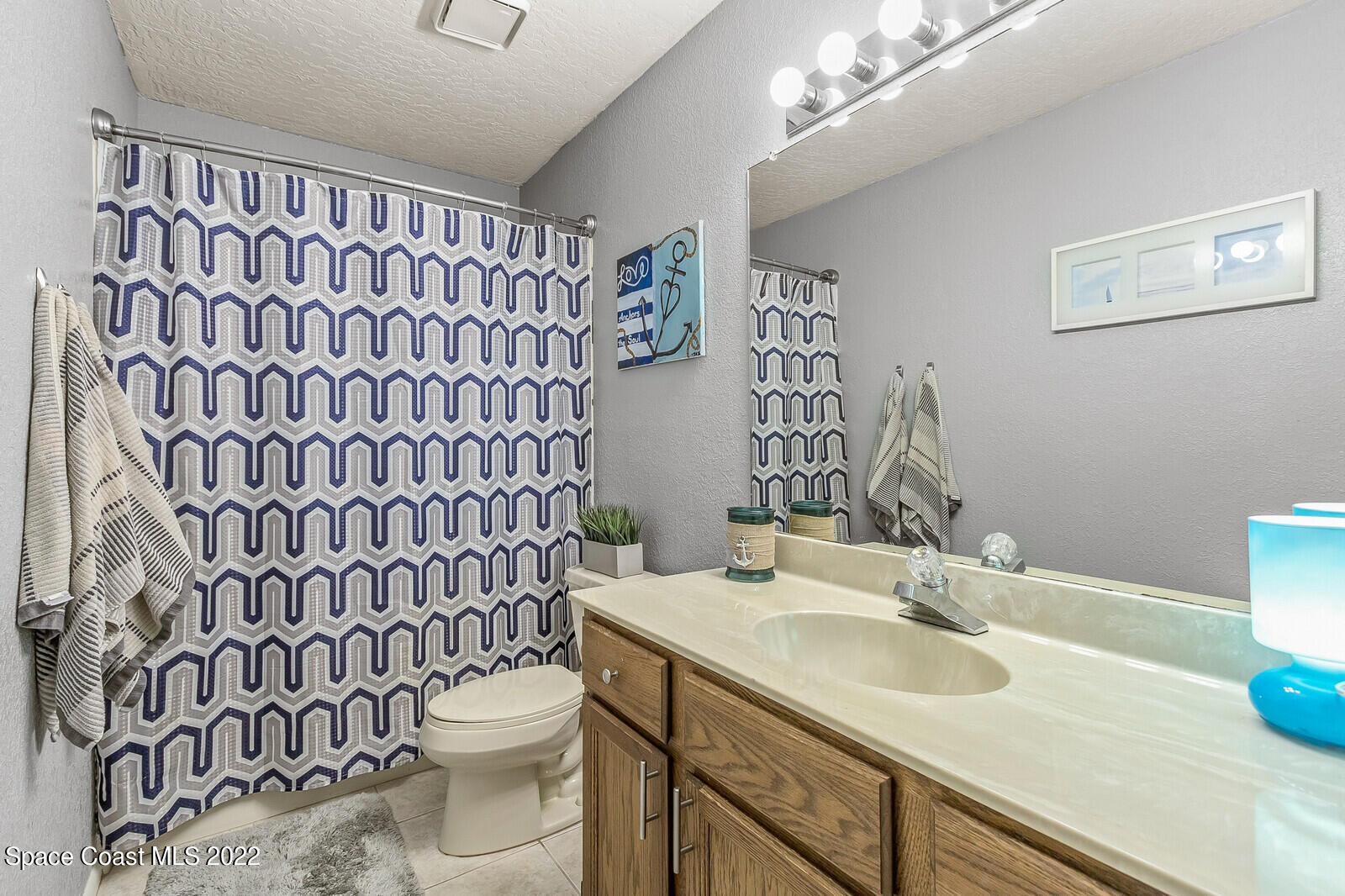 1784 Quail Trail Melbourne, FL 32935 - Photo 33 of 40 a bathroom with a sink a toilet and shower curtain