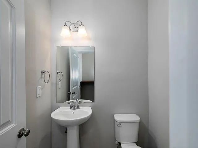 a bathroom with a sink mirror and toilet