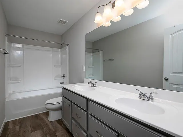 a bathroom with a sink a toilet and a mirror