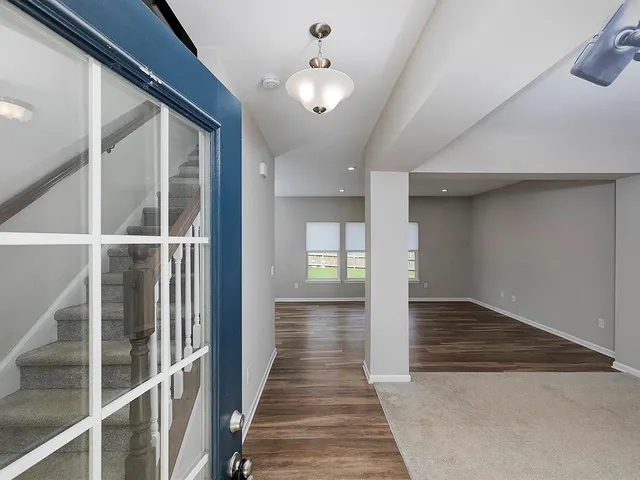 a view of a hallway with wooden floor and staircase