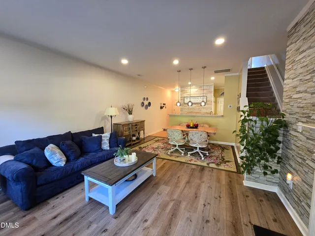 a living room with furniture kitchen view and a potted plant