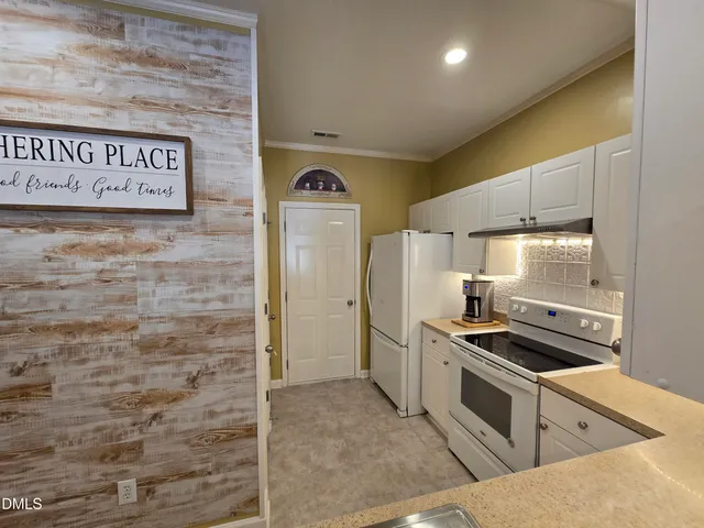 a kitchen with granite countertop a stove and cabinets