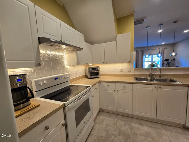 a kitchen with granite countertop white cabinets and white appliances
