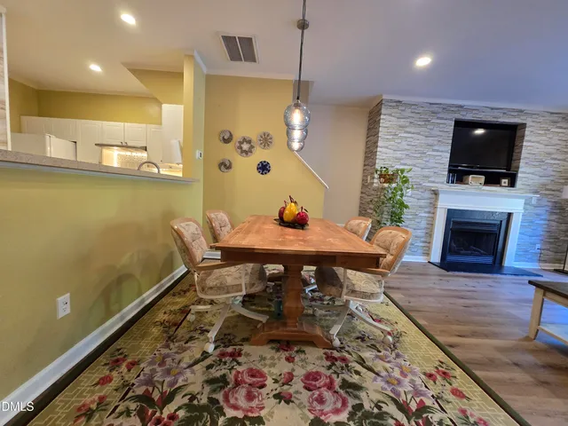 a living room with a dining table and a fireplace