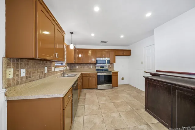 a kitchen with stainless steel appliances granite countertop a sink a stove and cabinets