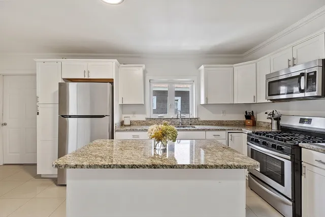 a kitchen with granite countertop a sink stainless steel appliances and cabinets
