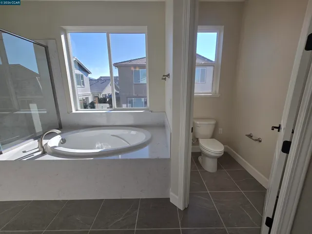 a bathroom with a granite countertop sink a toilet a mirror and vanity