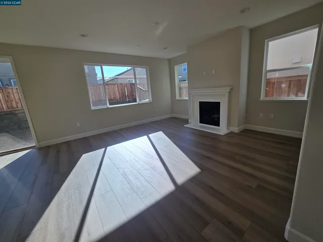 a view of a livingroom with wooden floor and fireplace