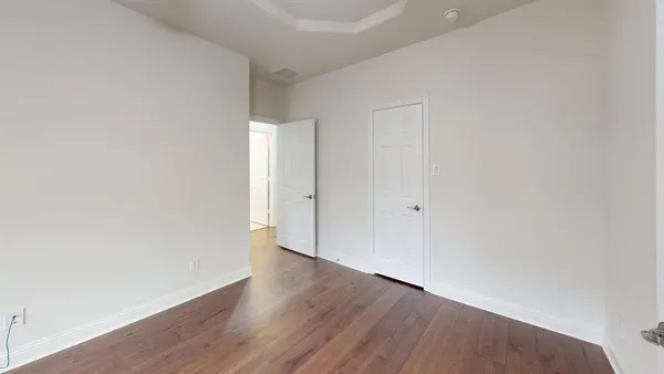 a view of an empty room with wooden floor