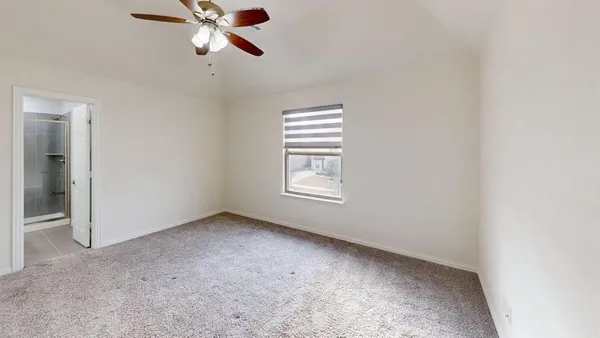an empty room with a window and a fan
