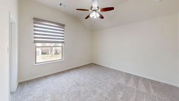 an empty room with a window and a fan