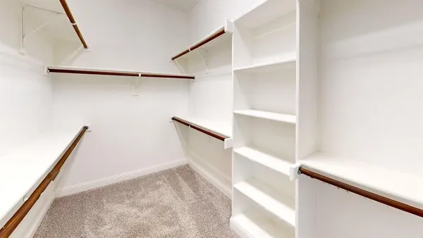 a view of walk in closet with empty racks