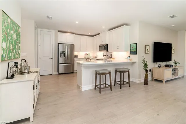 a kitchen with refrigerator and cabinets
