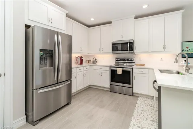 a kitchen with stainless steel appliances a refrigerator sink and microwave