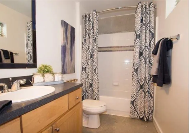 a bathroom with a sink a toilet and shower curtain
