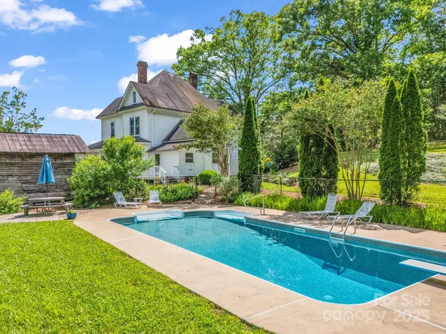 a view of a house with swimming pool and sitting area