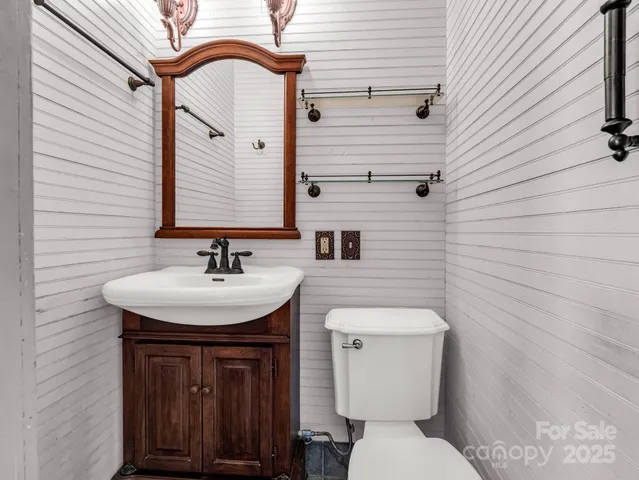 a bathroom with a sink a toilet and mirror