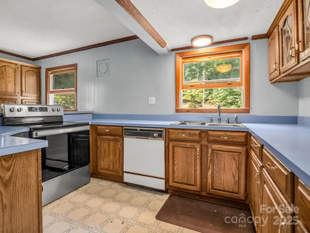 a kitchen with stainless steel appliances granite countertop a stove a sink and a microwave