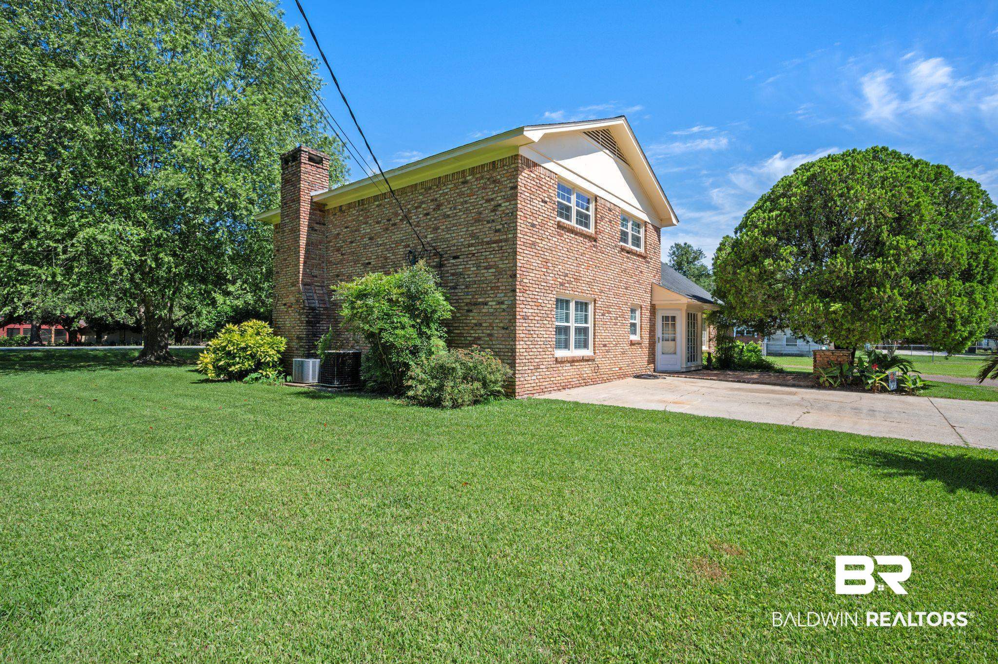 950 Walter Smith Road Mobile, AL 36695 - Photo 30 of 51 View of side of property featuring a chimney, brick siding, and a lawn