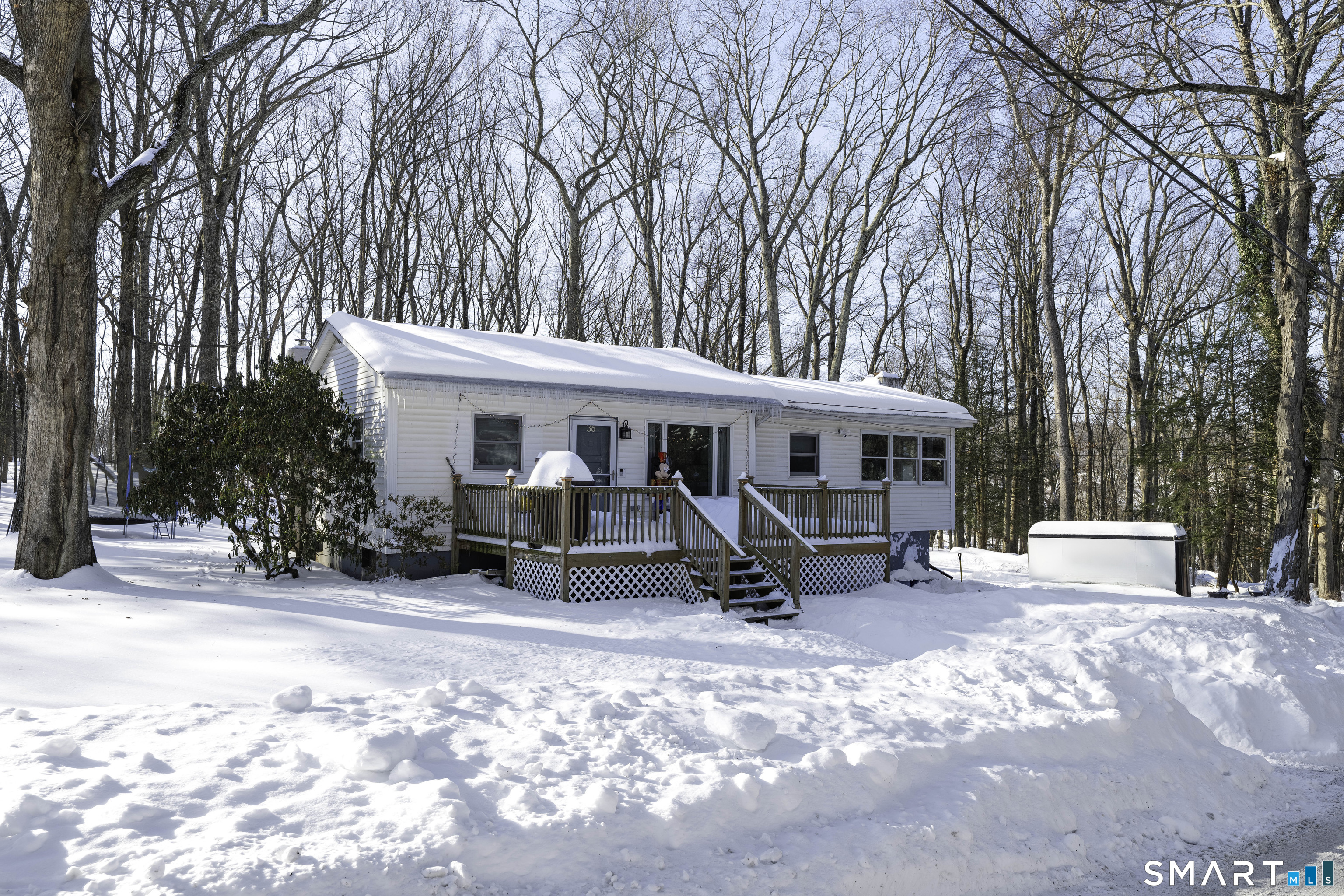 36 Maple Drive New Milford, CT 06776 - Photo 2 of 24 a view of a house with sitting area and covered with tall trees