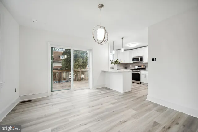 a large kitchen with cabinets wooden floor and stainless steel appliances