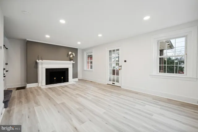 a view of an empty room with a fireplace and a window