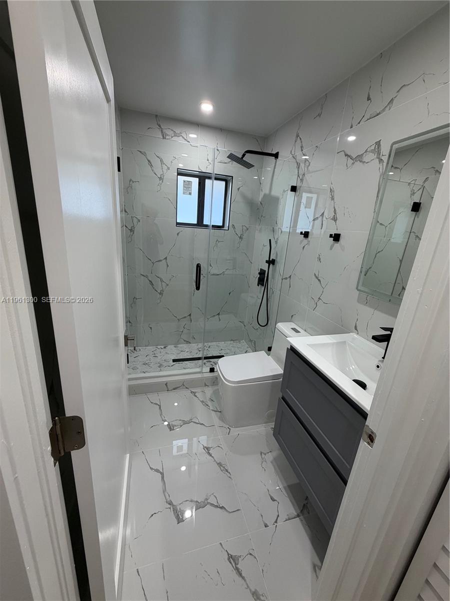 18940 Southwest 113th Court Miami, FL 33157 - Photo 14 of 30 a bathroom with a sink a toilet a mirror and shower