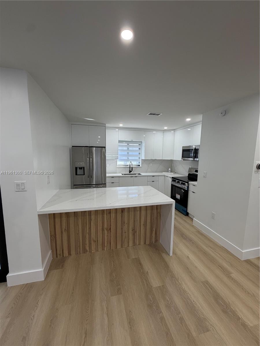18940 Southwest 113th Court Miami, FL 33157 - Photo 7 of 30 a living room with stainless steel appliances kitchen island a sink a refrigerator and a stove