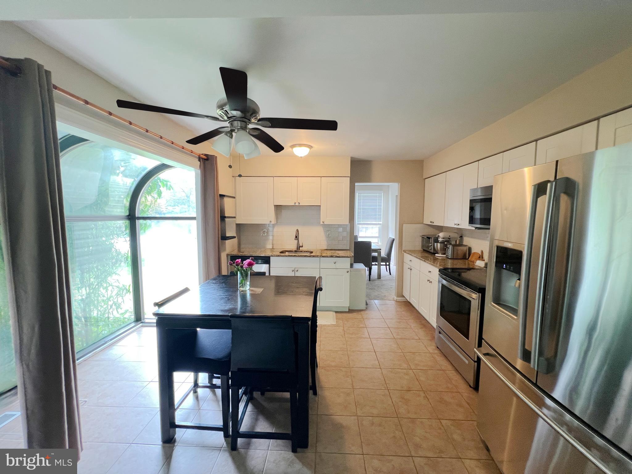 203 Spring Drive Voorhees, NJ 08043 - Photo 15 of 21 a kitchen with stainless steel appliances granite countertop a refrigerator a sink a stove and white cabinets