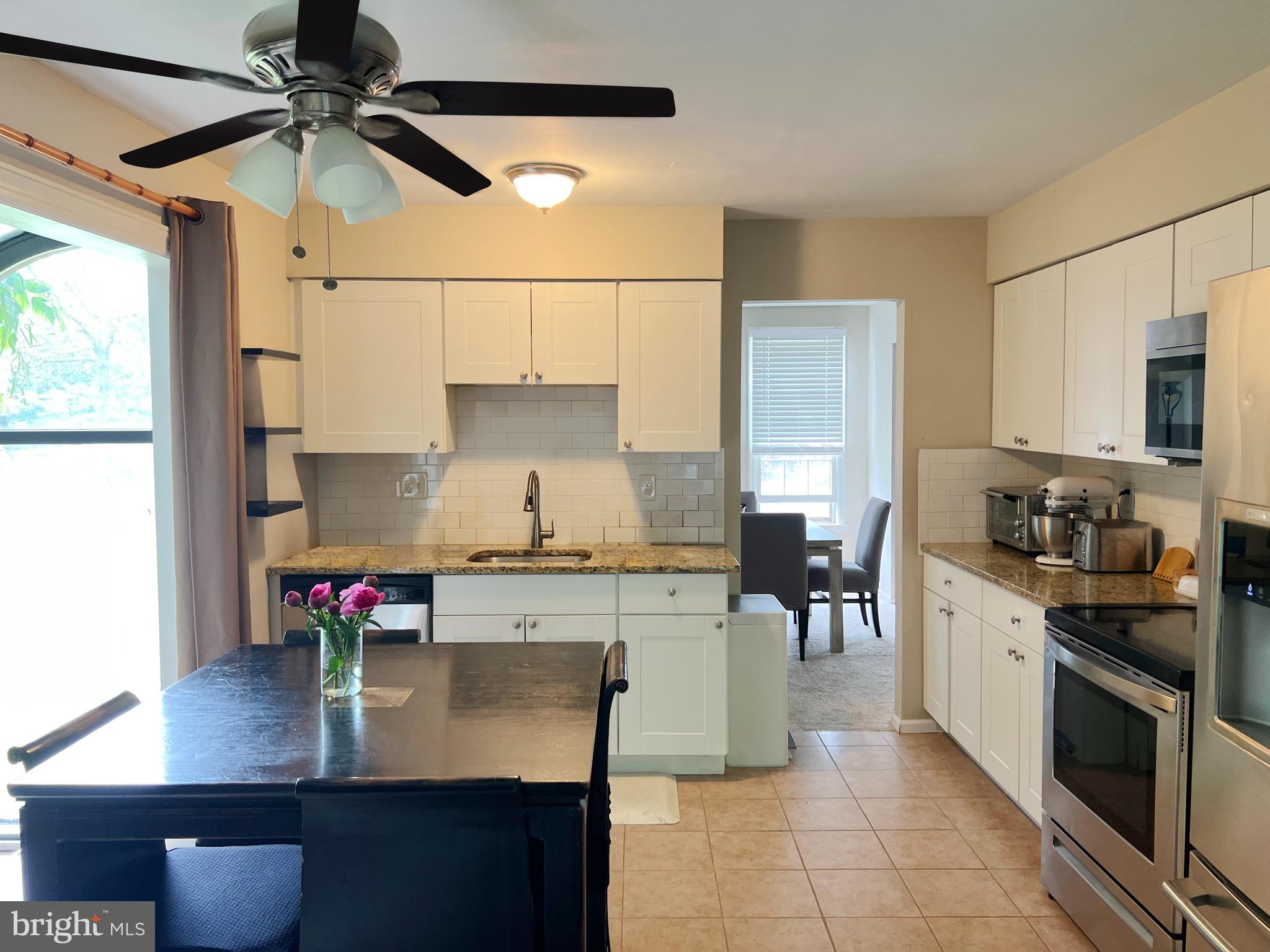 203 Spring Drive Voorhees, NJ 08043 - Photo 16 of 21 a kitchen with kitchen island granite countertop a sink appliances cabinets and a counter top space