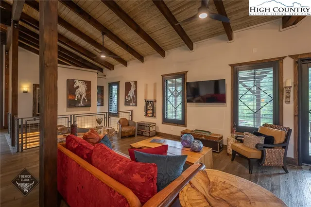 a living room with furniture a flat screen tv and a large window