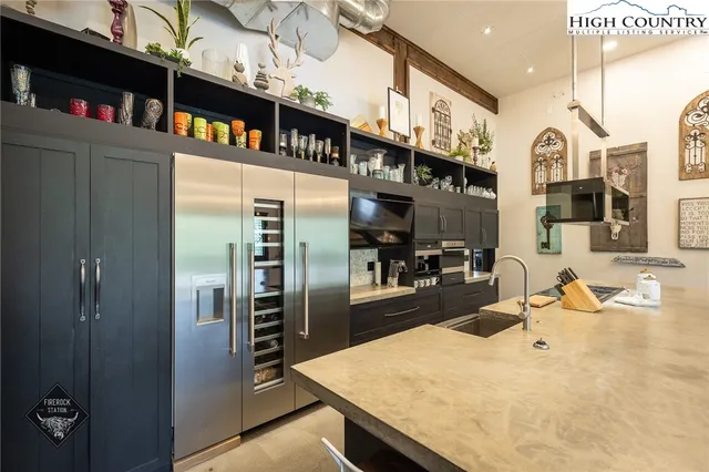 a living room with furniture a flat screen tv and kitchen view