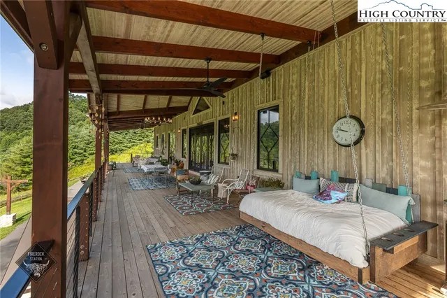 a outdoor space with the couches and dining table under an umbrella