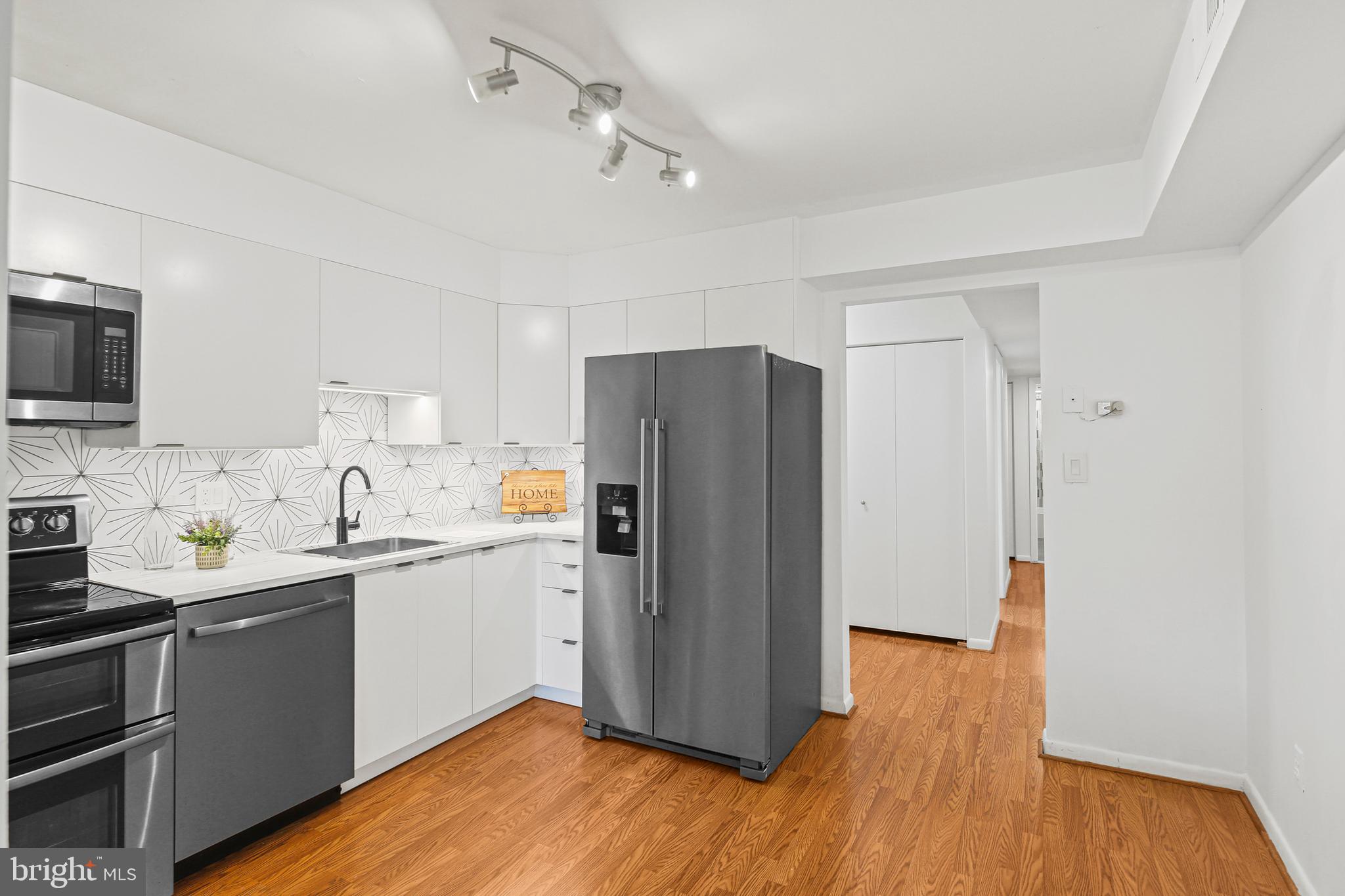 2 Bailiffs Court, Unit 102 Lutherville-Timonium, MD 21093 - Photo 2 of 34 a kitchen with a sink a refrigerator a stove and cabinets
