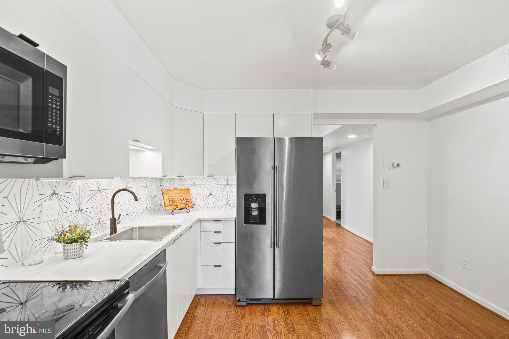 2 Bailiffs Court, Unit 102 Lutherville-Timonium, MD 21093 - Photo 3 of 34 a kitchen with granite countertop a refrigerator and a sink