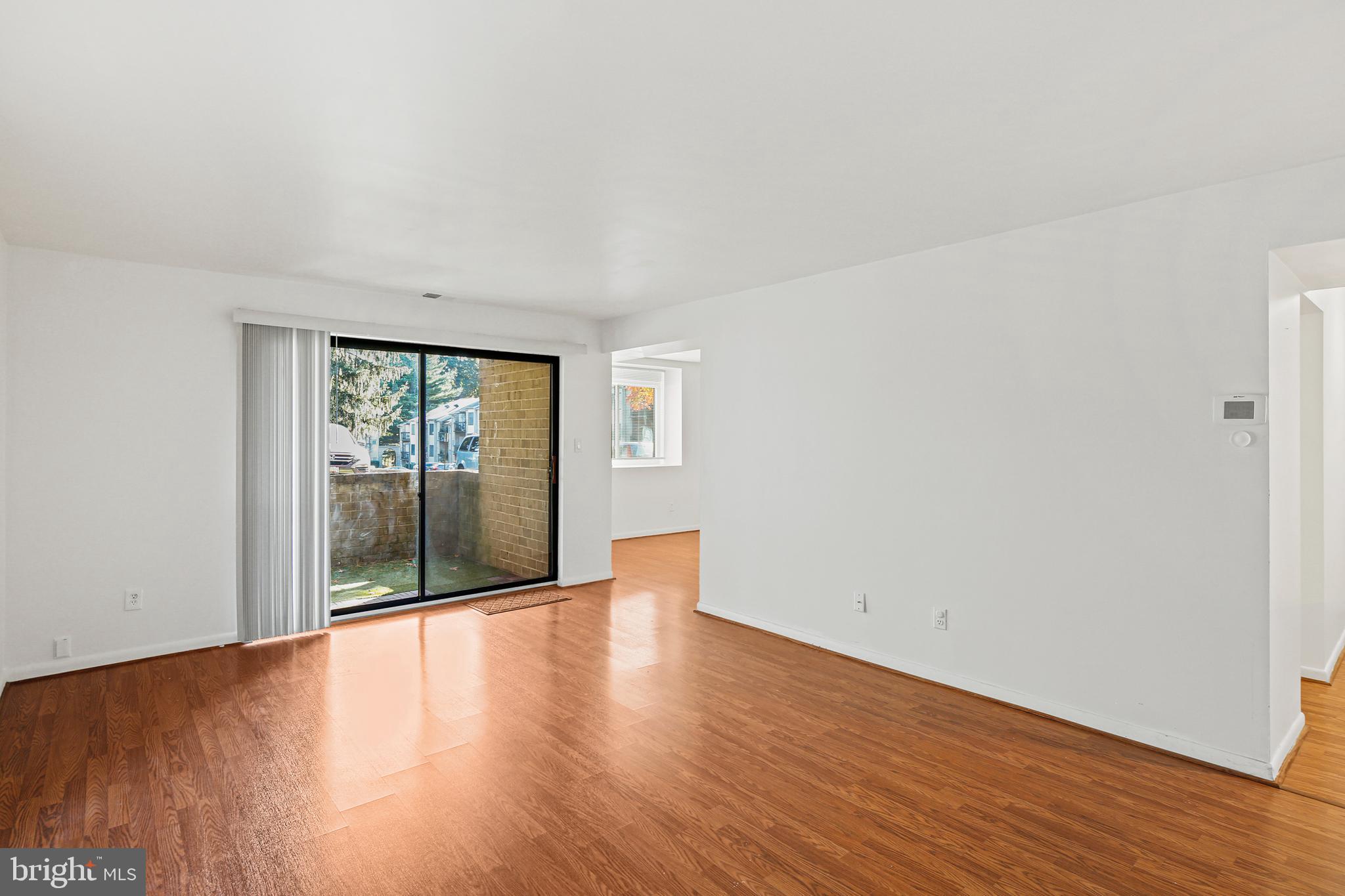 2 Bailiffs Court, Unit 102 Lutherville-Timonium, MD 21093 - Photo 6 of 34 an empty room with wooden floor and windows
