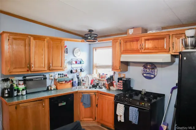 a kitchen with stainless steel appliances granite countertop a stove a sink dishwasher and cabinets with wooden floor