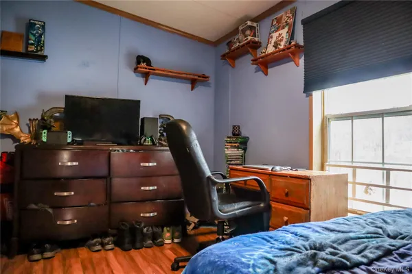 a bedroom with a bed and a flat tv screen