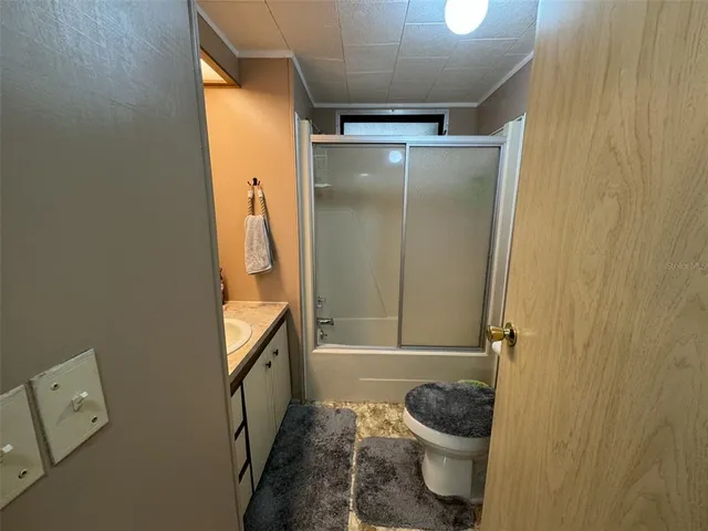 a spacious bedroom with a bed a chandelier and a dresser