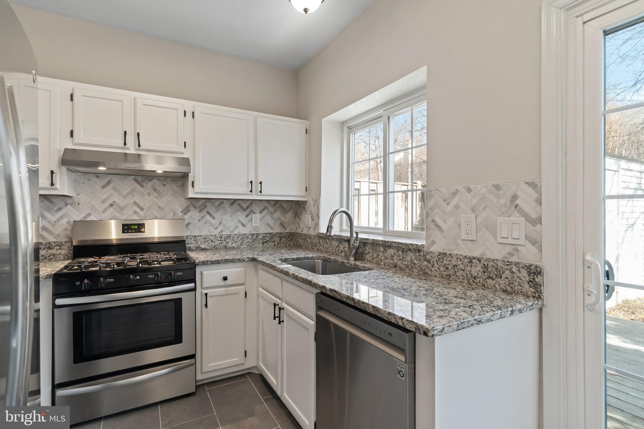 7115 Strawn Court Alexandria, VA 22306 - Photo 12 of 27 a kitchen with granite countertop stainless steel appliances white cabinets granite counter tops and a window