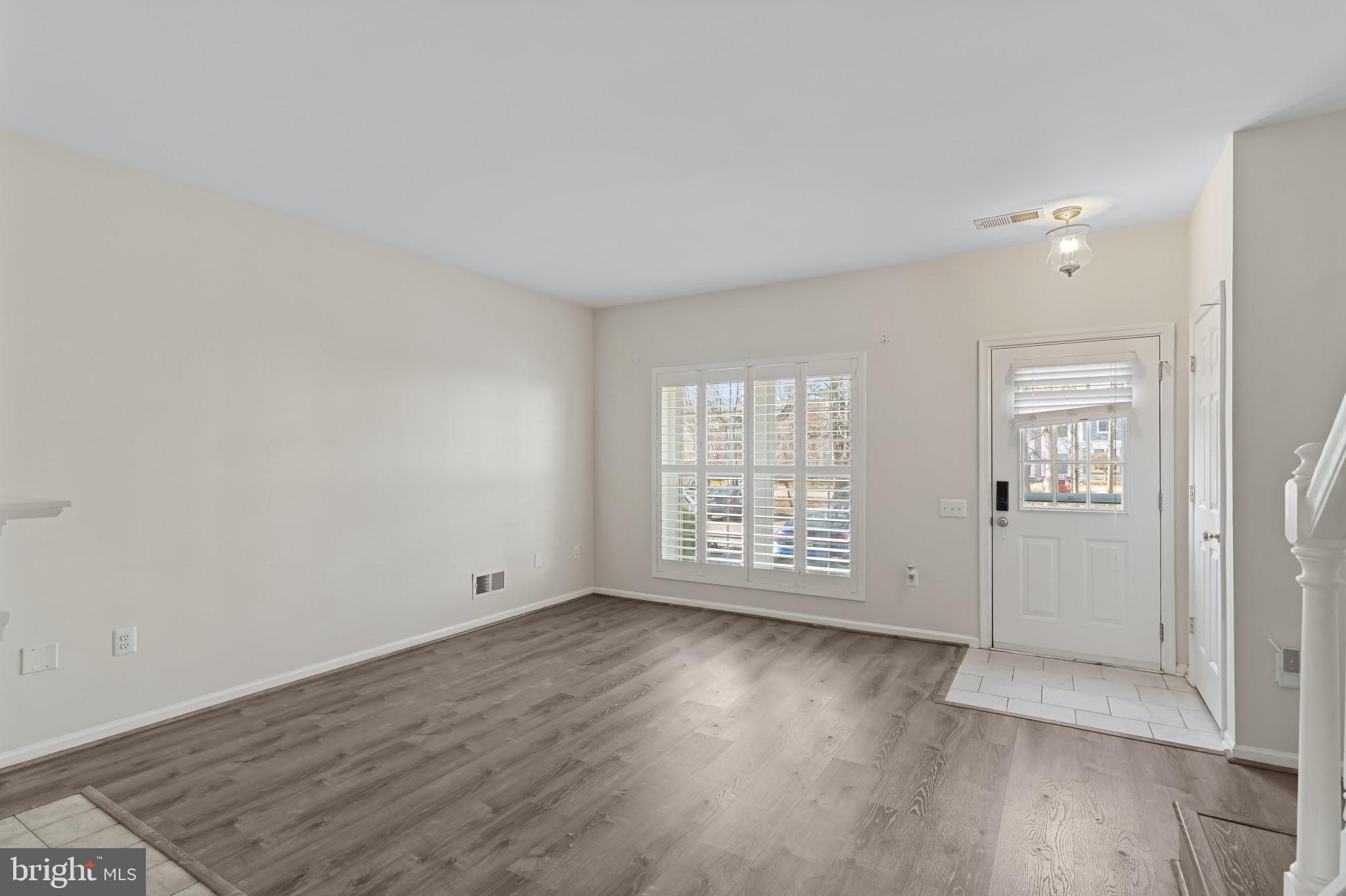 7115 Strawn Court Alexandria, VA 22306 - Photo 7 of 27 an empty room with wooden floor and windows