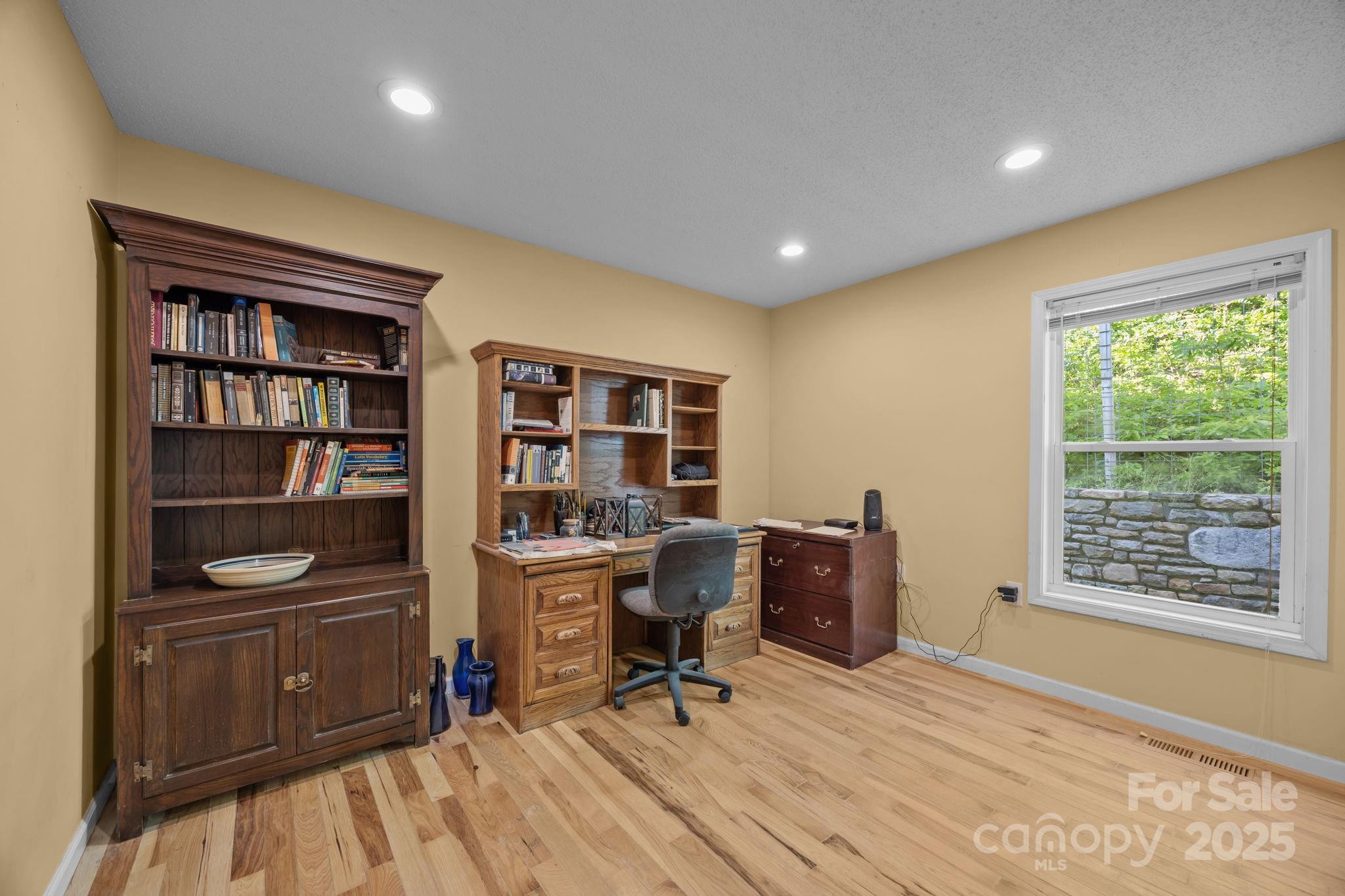 55 Pine Bluff Road Hendersonville, NC 28792 - Photo 19 of 47 a view of a workspace with furniture and a bookshelf