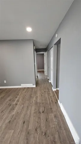 a view of empty room with wooden floor and entryway