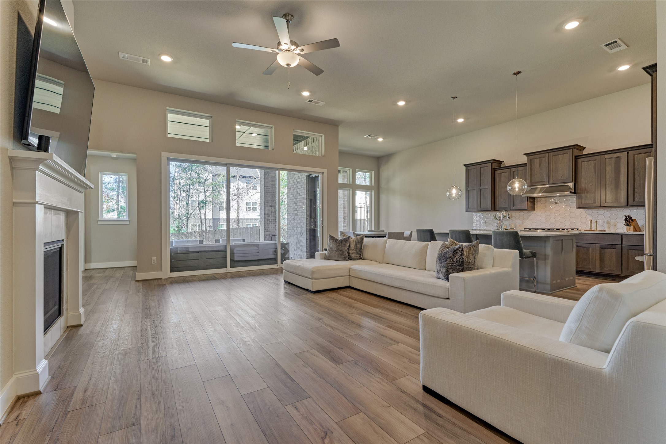 1716 Encino Boulevard Conroe, TX 77304 - Photo 12 of 50 Experience a seamless transition from cooking to dining to relaxing with this open-concept layout. A wall of glass sliders open to the covered patio.