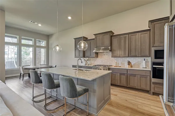 a large kitchen with cabinets a sink and chairs